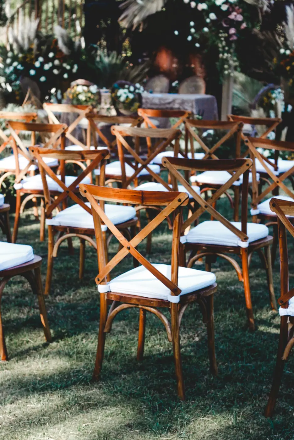 Wooden ceremony chairs arranged for an outdoor event